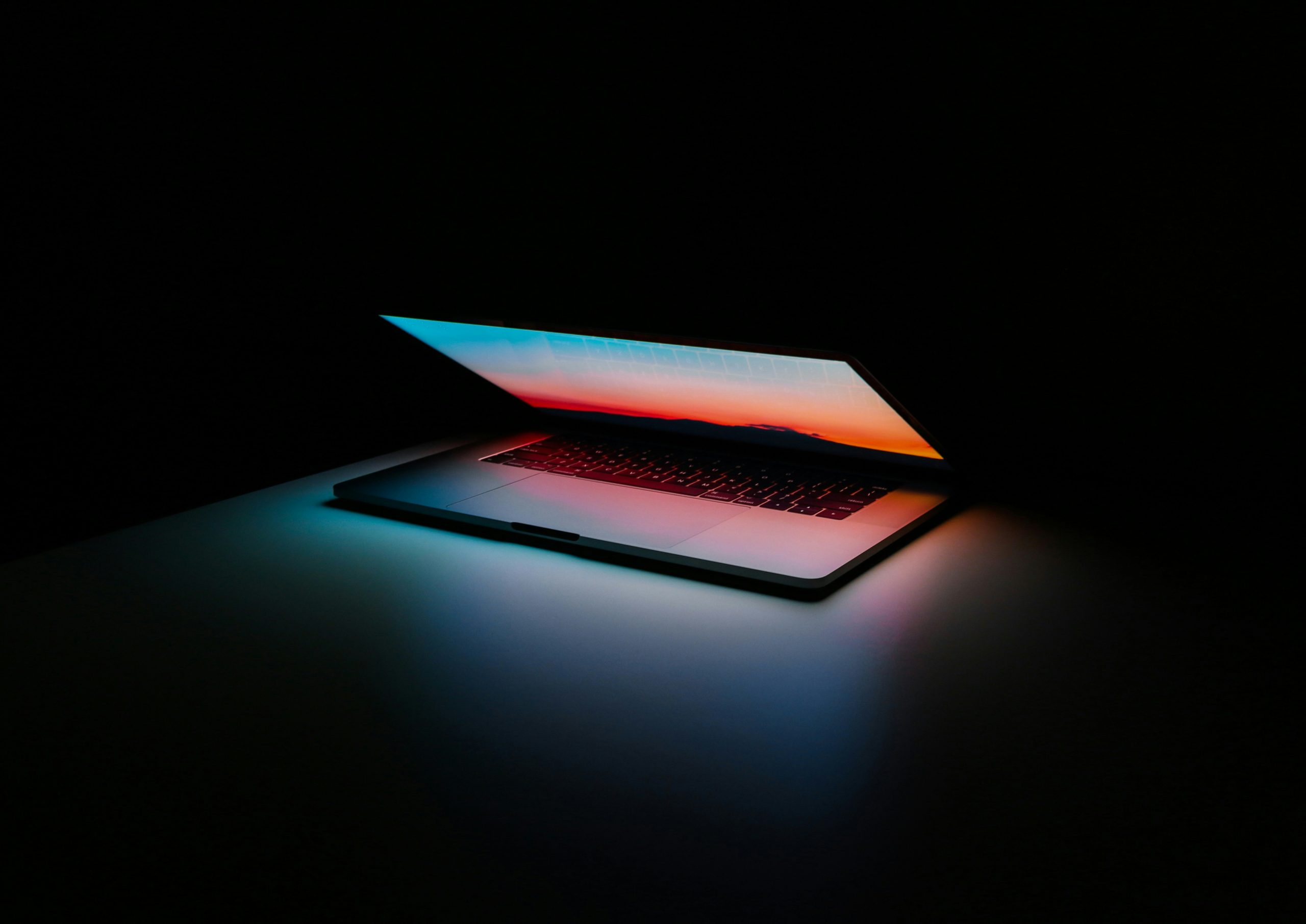 half-closed laptop against a dark background signifying the end of ad technology