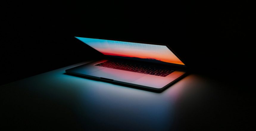 half-closed laptop against a dark background signifying the end of ad technology