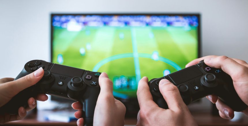 audience insights, video gamers, two game consoles in front of a tv showing a soccer video game