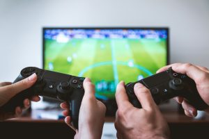 audience insights, video gamers, two game consoles in front of a tv showing a soccer video game